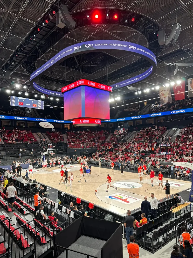 A full arena with a circular screen above the court before tip-off